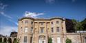 A large Bath stone building in beautiful gardens at American Museum and Gardens