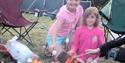 children roasting marshmallows over a fire at Stubcroft Farm Campsite