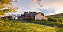 The outside of Elderburn Lodges. Image taken through trees