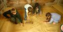 Four children playing in the sand, digging for dinosaur bones