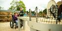A boy and young girl in a wheelchair are playing crazy cues, a game of golf and snooker