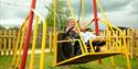 A girl in a wheelchair on an accessible swing
