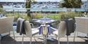 Outdoor tables set for dinner with views across the harbour at Sumas Restaurant