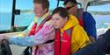 a group of people steering a boat wearing life jackets from Wetwheels Jersey