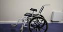 Wheelchair on a blue carpet and white wall in background