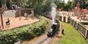 Steam train passing by a play area at Moors Valley Country Park and Forest