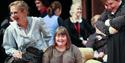 Person with Down's Syndrome sitting in a chair as part of a workshop, surrounded by people at Theatre by the Lake