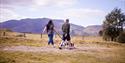 Couple walking their dogs through the countryside at Experience Freedom Glamping at Troutbeck Head