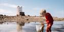 Child rockpooling while on a walk with Jersey Walk Adventures