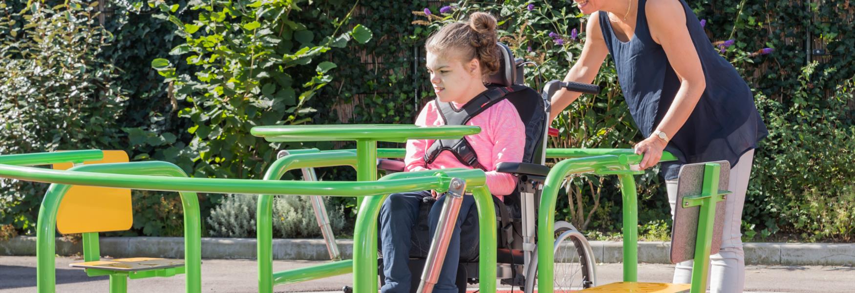 Child in wheelchair playing on accessible play equipment