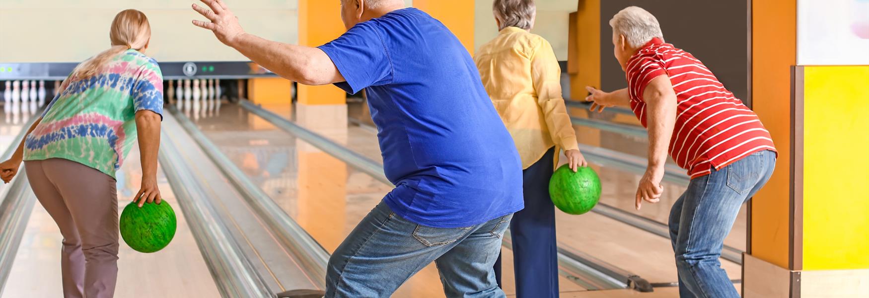 Elderly people playing ten pin bowling