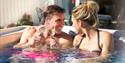 Couple in hot tub at The Bay Colwell Holiday Resort, Isle of Wight, Self Catering