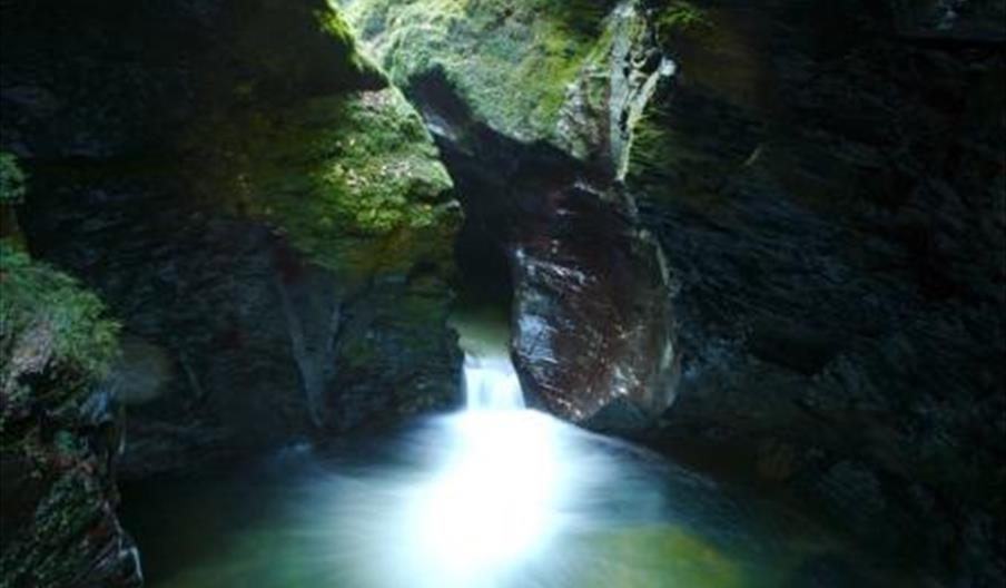 Water flowing into Devil's Cauldron pothole through narrow gap, Lydford Gorge, Devon