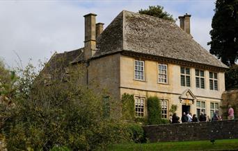 View of Snowshill Manor from the Orchard with visitors