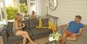 Family enjoying open plan living and dining area of self catering cottage at The Bay Colwell Holiday Resort, Isle of Wight