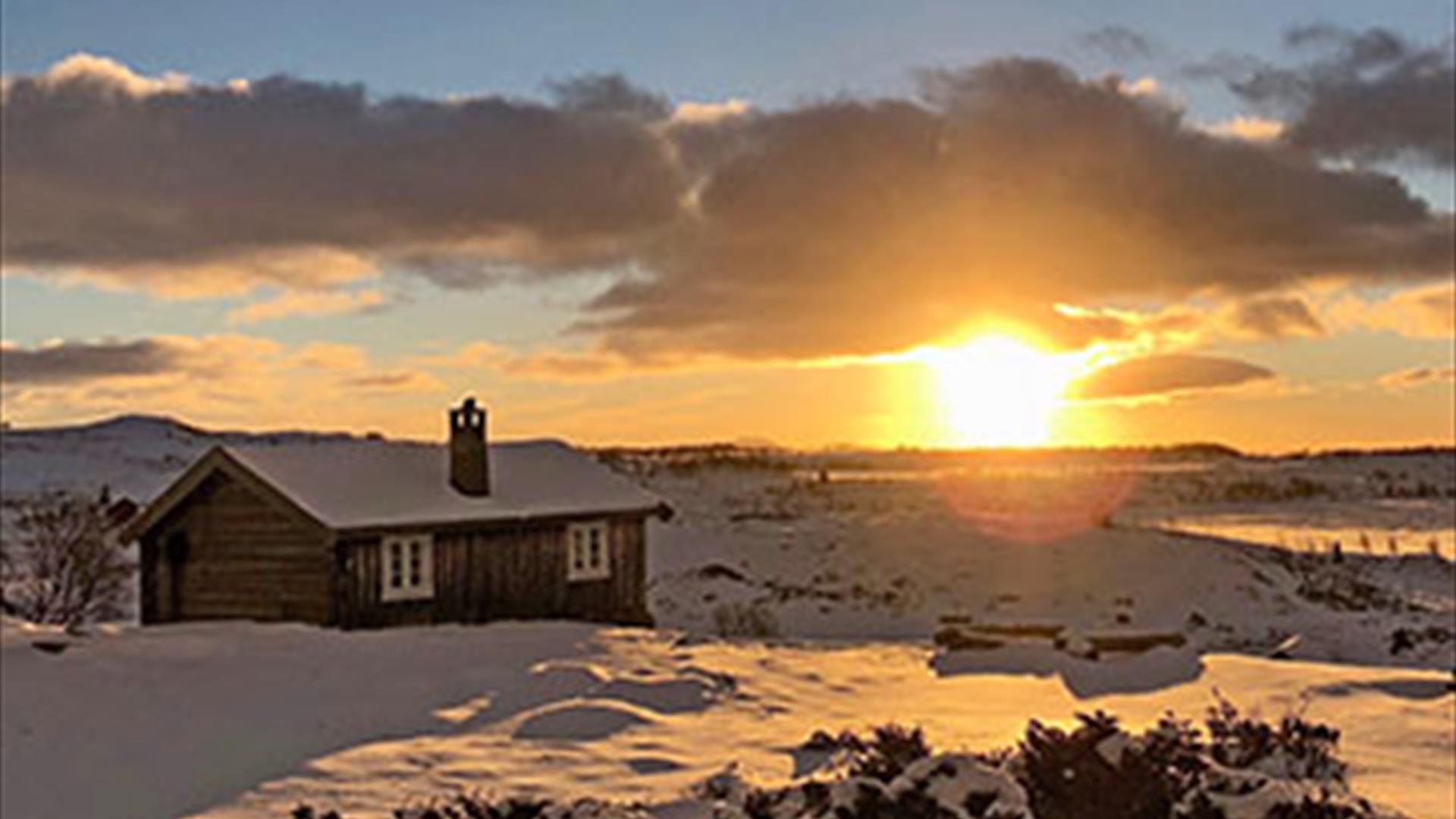 Small farm cabin in the mountains during wintersunset