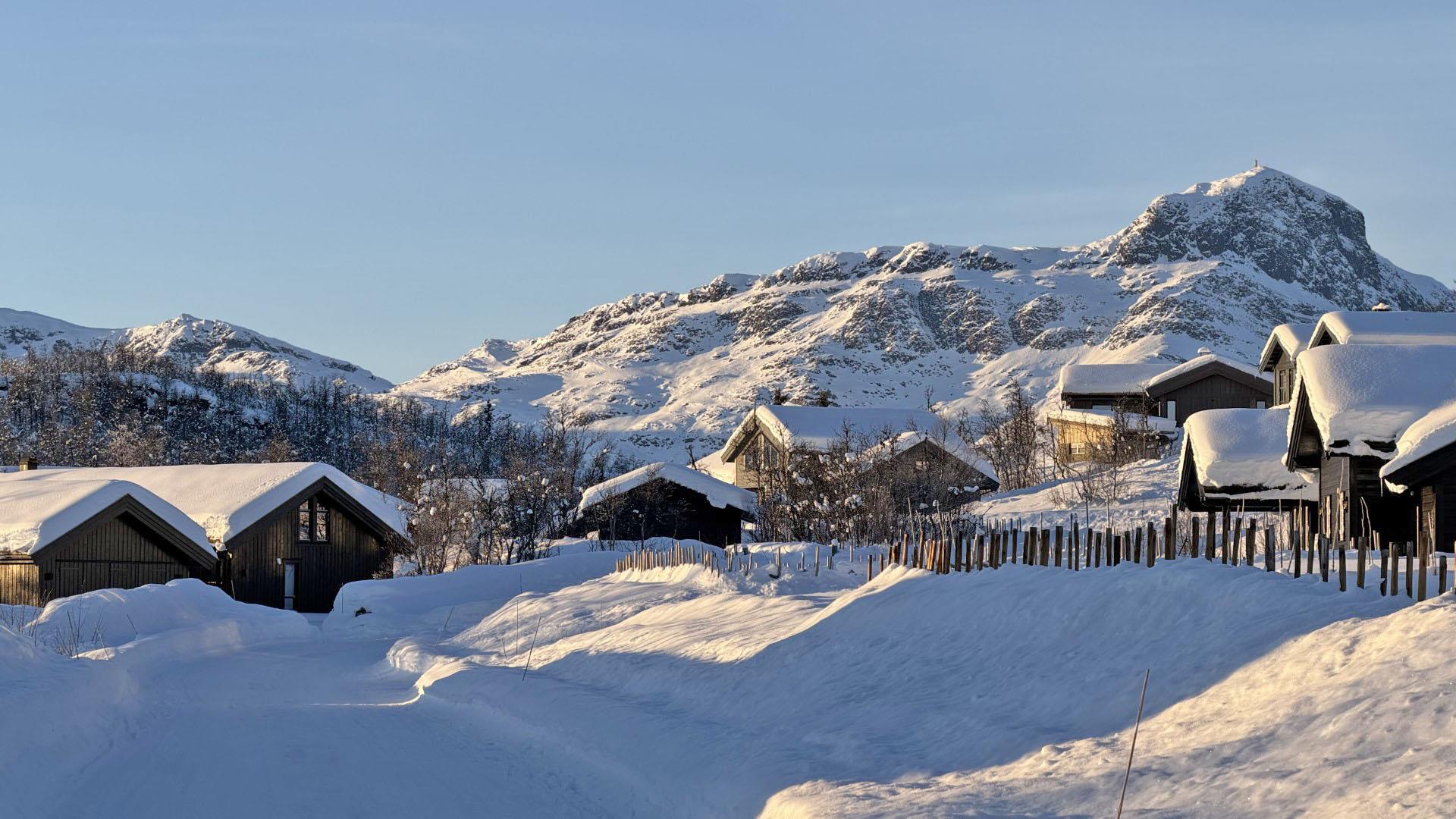 Hytter i vakkert, vinterlig landskap med Bitihorn i bakgrunn