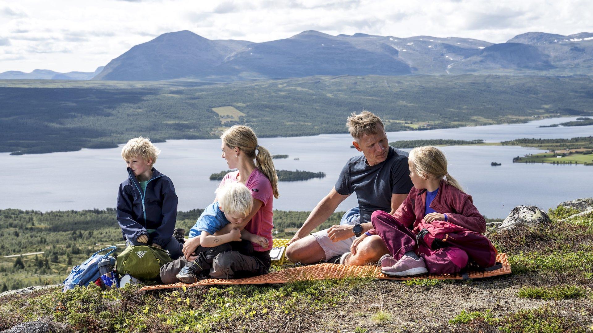 Familie spiser lønsj på fjellet