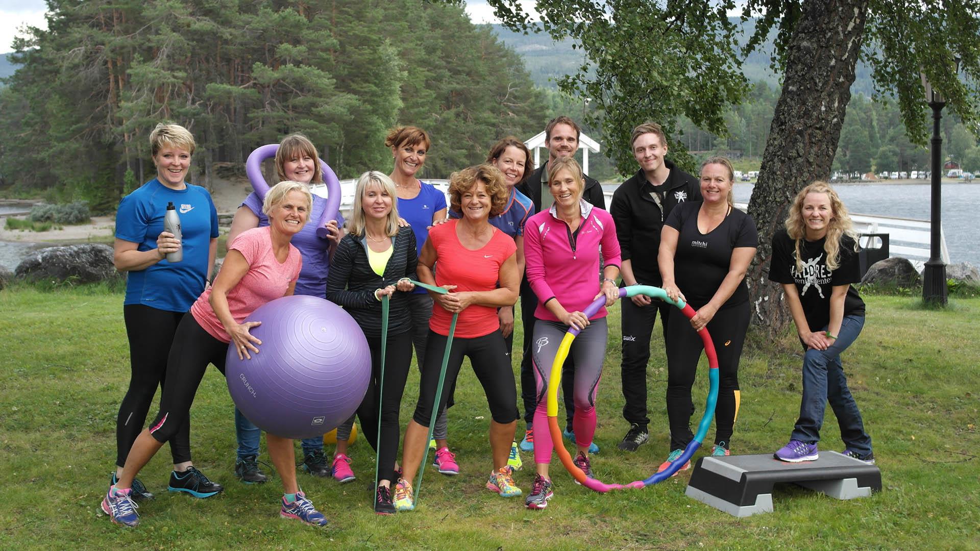 Trenerne på Toten Treningssenter i Valdres med apparater i hagen utenfor treningssenteret.