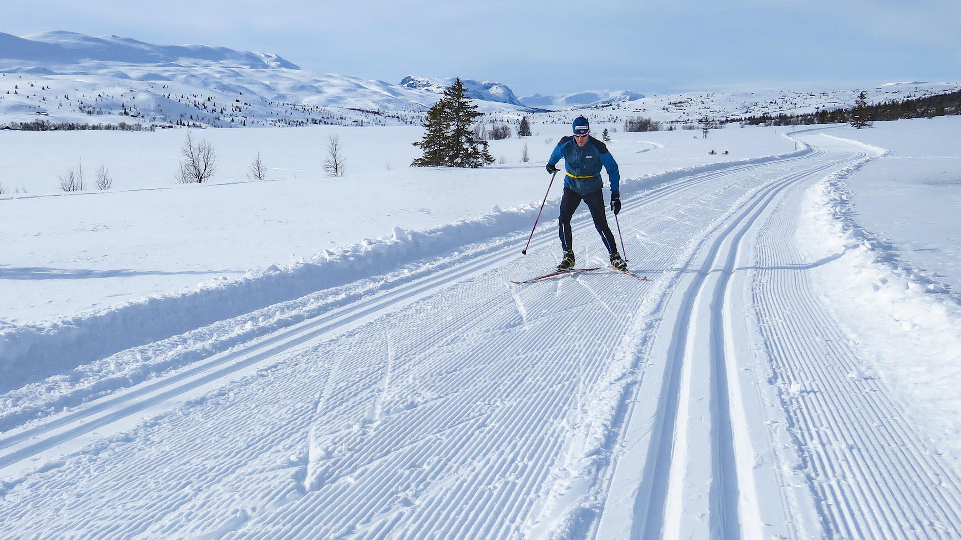 Man skiing in slopes in the Syndin area. Mountains in the background