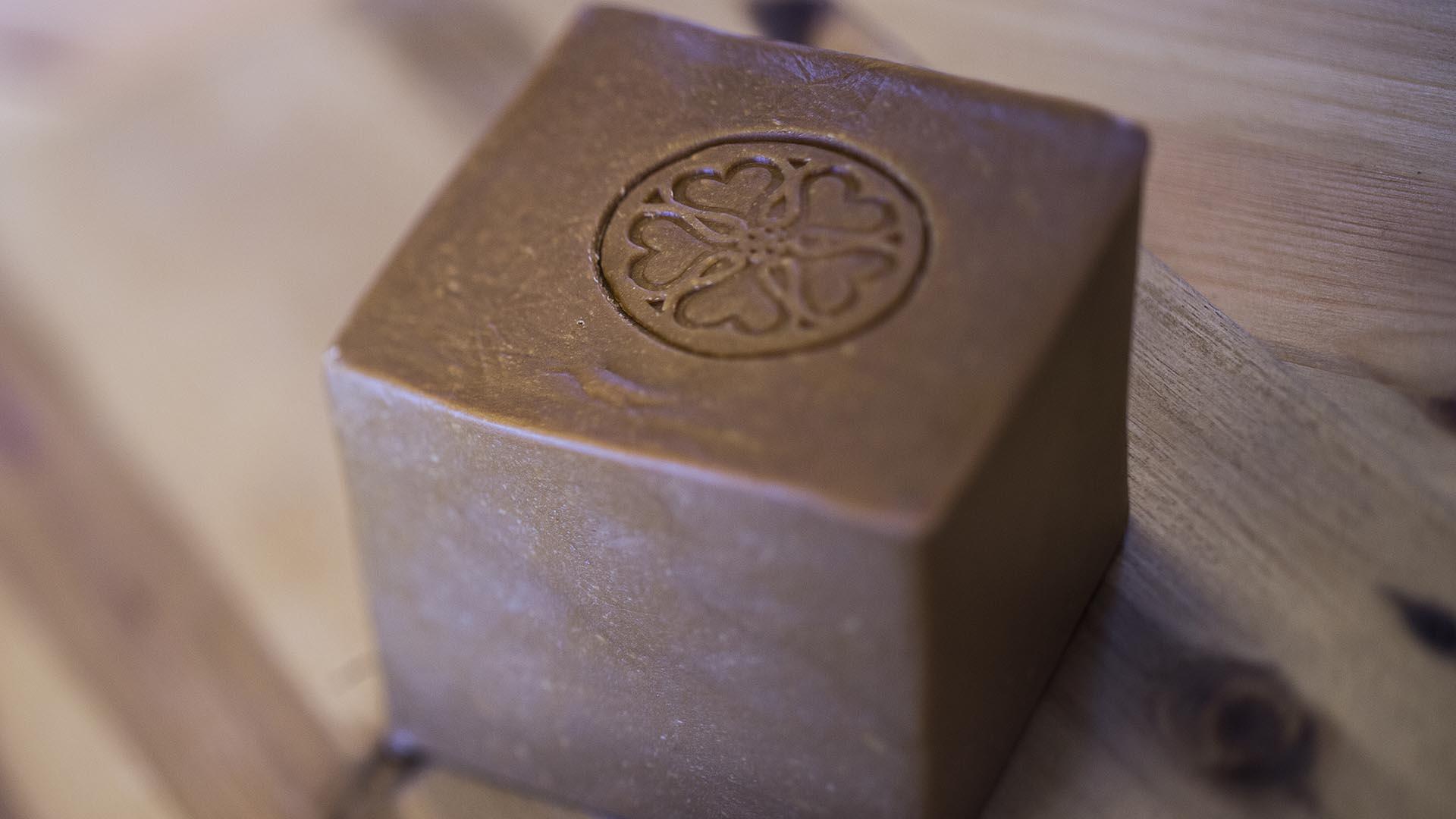 On a wooden table, a close up photo of a locally produced brown cheese.