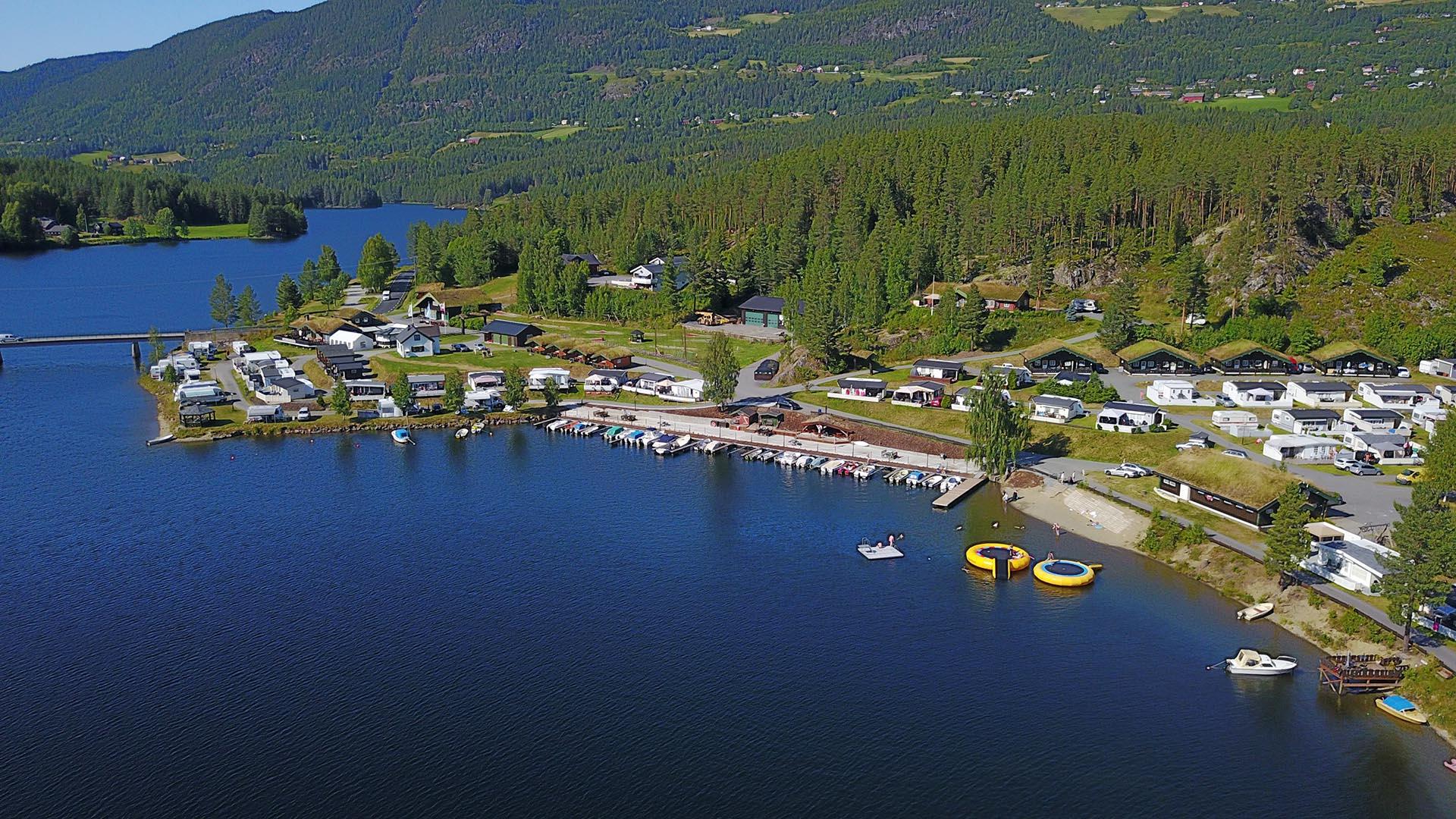 Flyfoto over Aurdal fjordcamping med strandsone og innsjø.