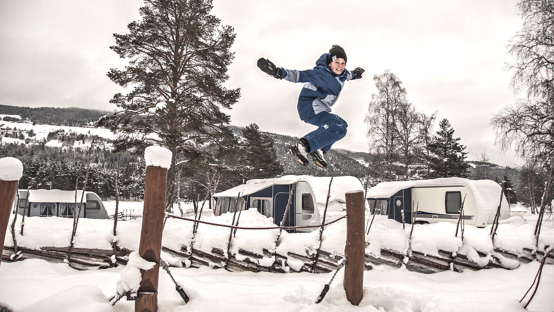 Child jumping from joy in a snowy Fagernes Camping