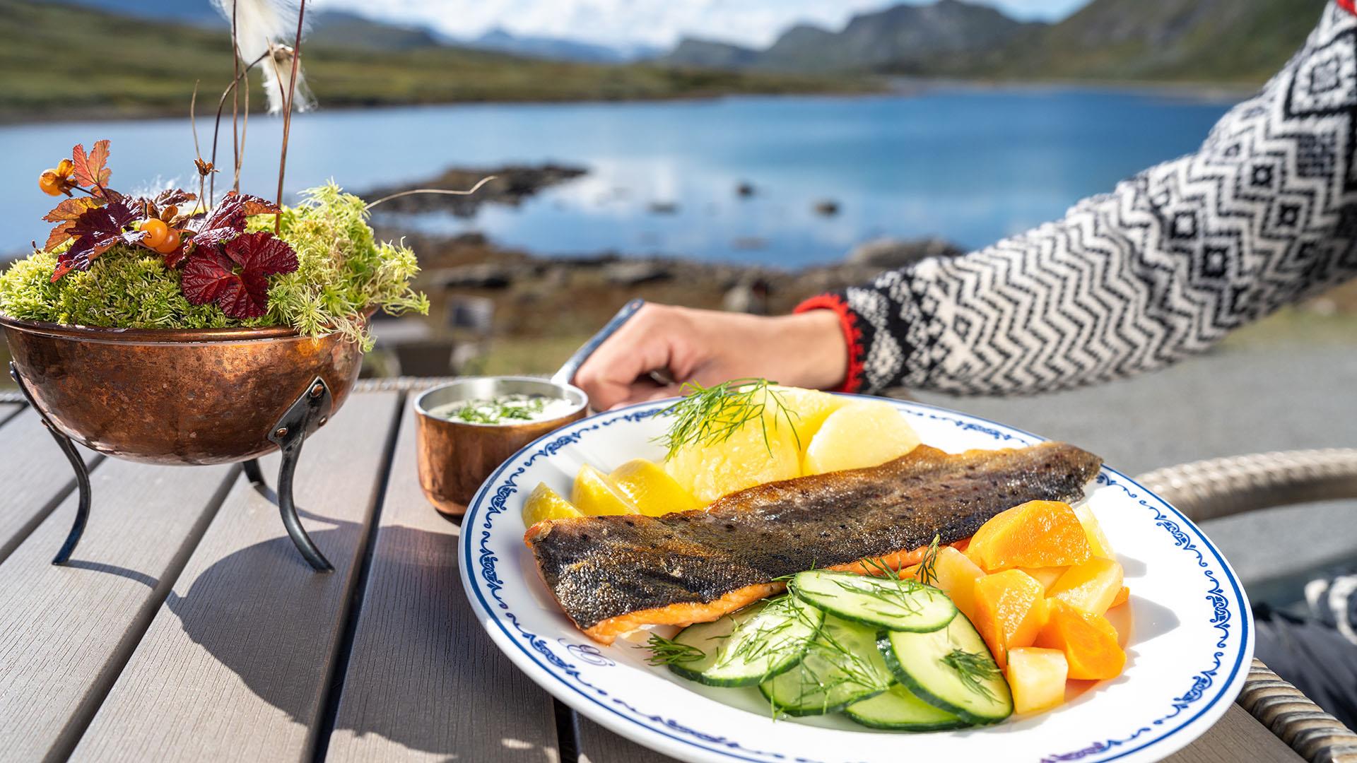 Plate with trout dish on sunny deck overlooking water