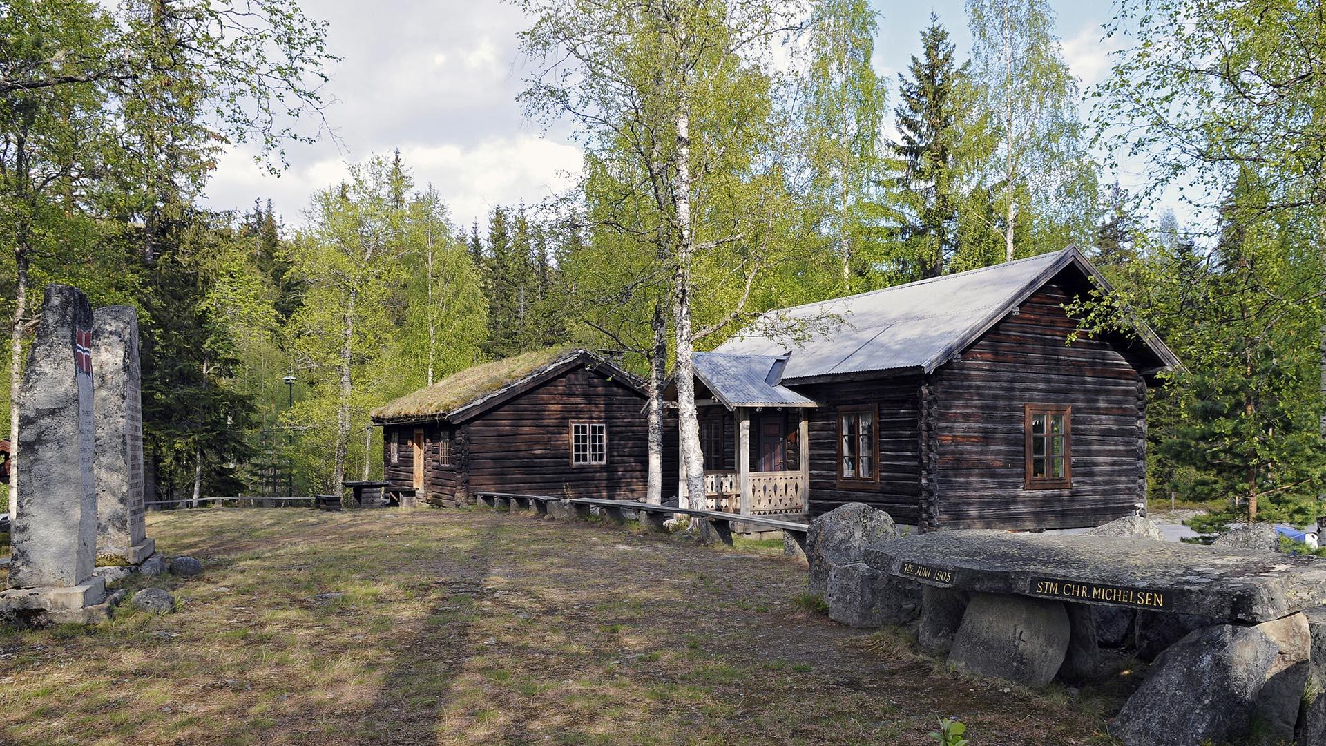 Im Heimatmuseum Bautahaugen Samlinger mit zwei Gedenksteinen und zwei alten Blockhäusern.