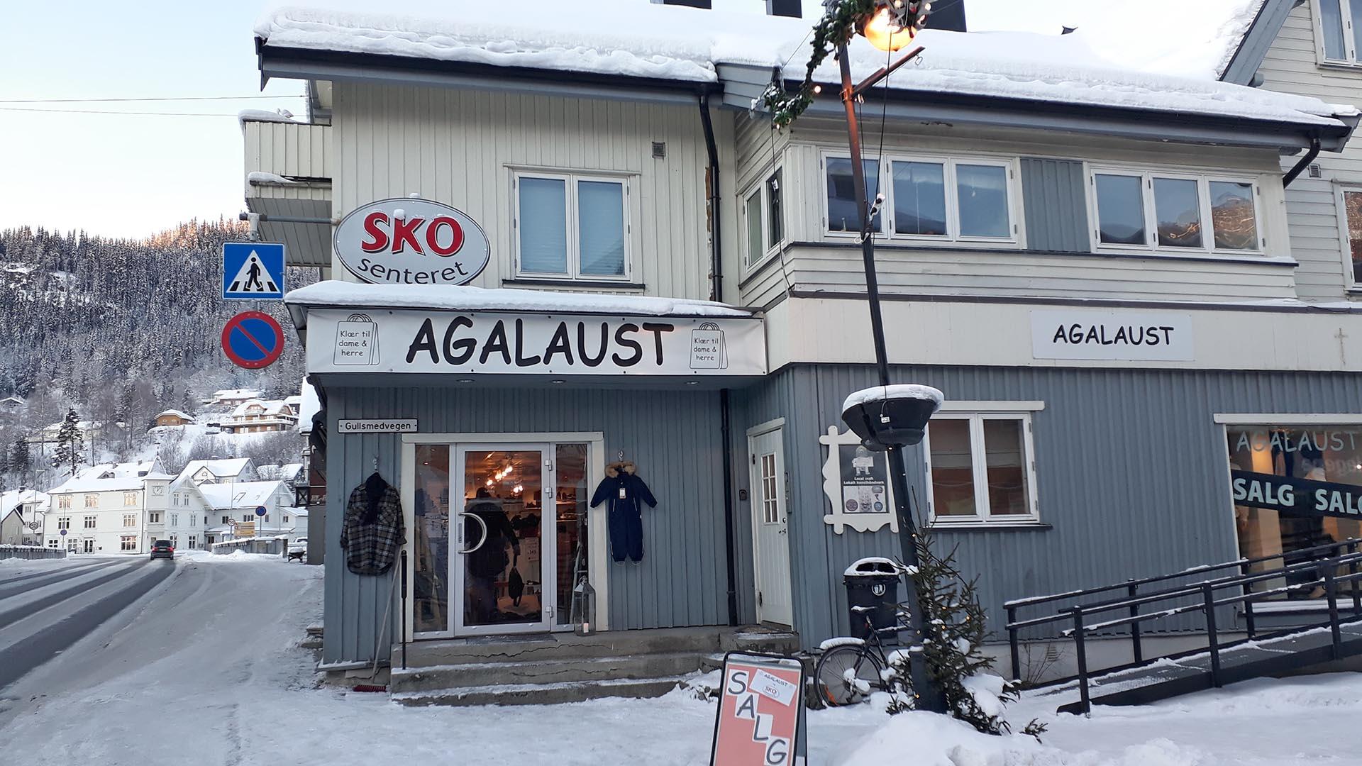 A two story high wooden house with shops on the ground floor a winters day.