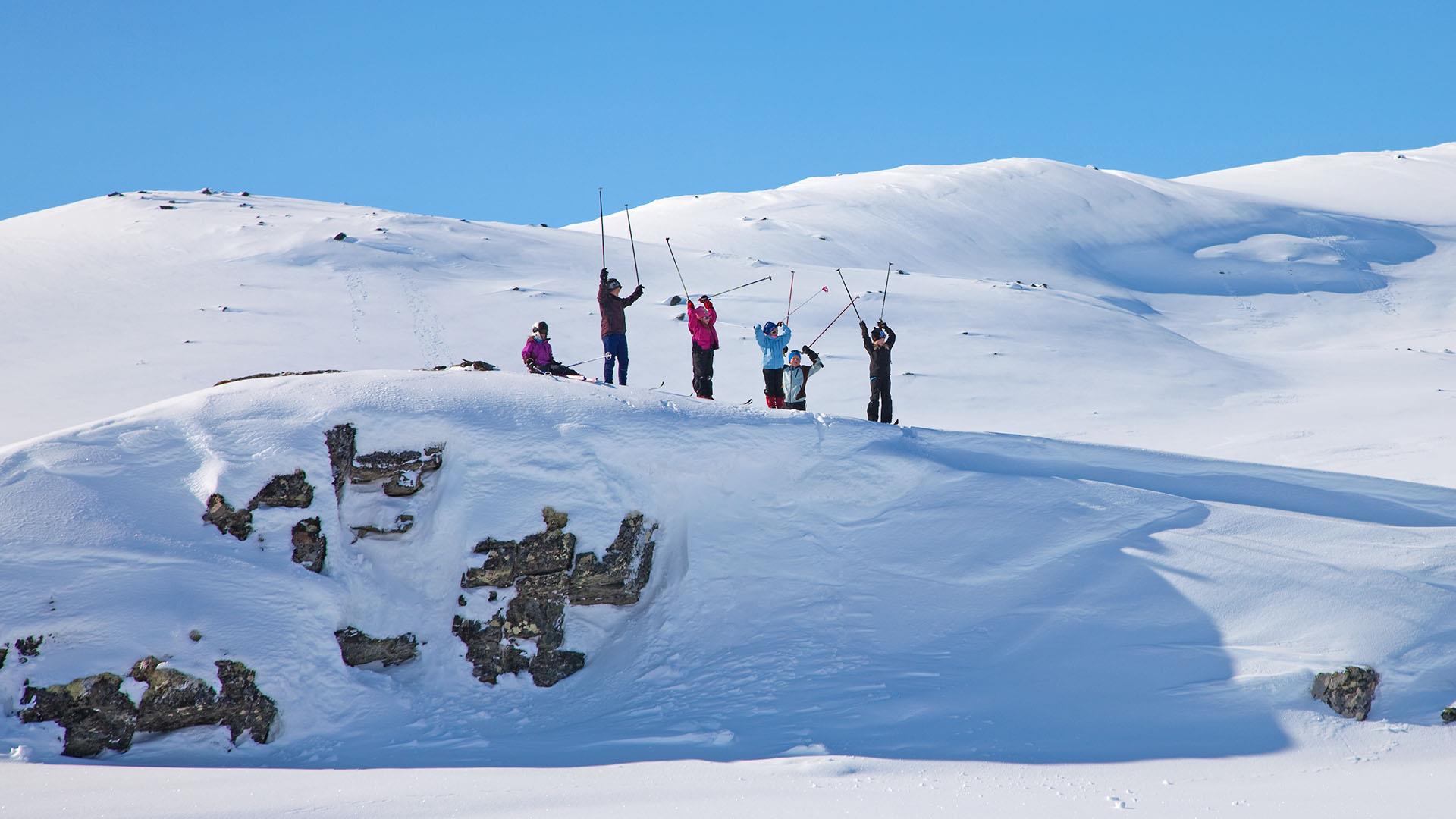 Glade skiløpere på fjellet en flott vinterdag