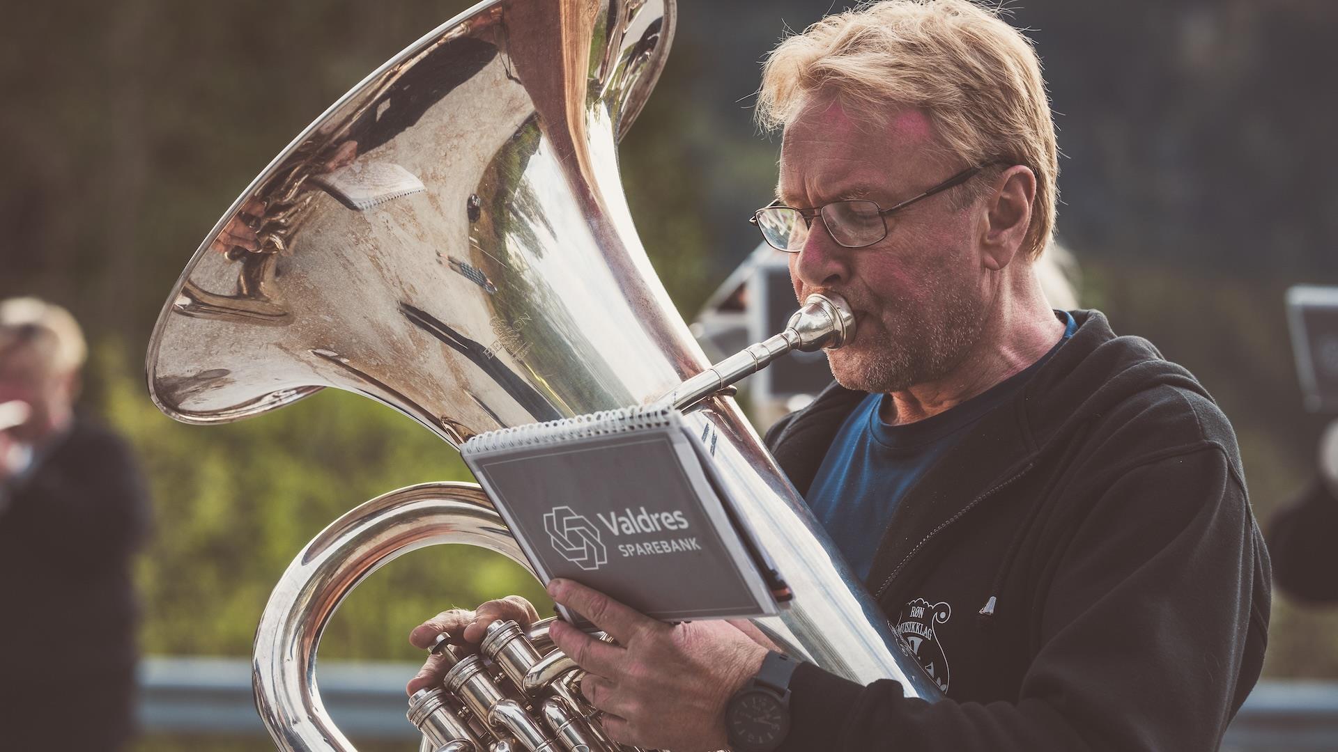 mann spiller tuba i korps