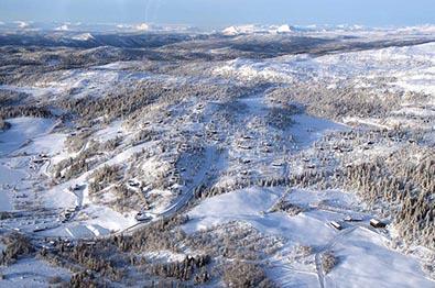 Oversiktsbilde over vinterlig fjellandskap med hytter