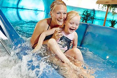 Mutter und Kind auf einer Wasserrutsche in eneim Schwimmbad
