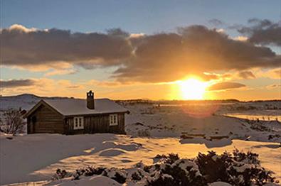 Small farm cabin in the mountains during wintersunset