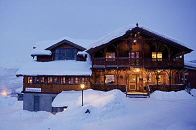 Filefjellstuene med belysning en mørk vinterdag