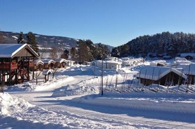 Vinterbilde av Fagernes Camping med blå himmel.