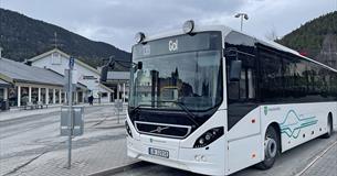 En hvit buss med Innlandstrafikk sin logo på Fagernes Skysstasjon
