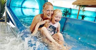 Mutter und Kind auf einer Wasserrutsche