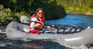 Eine Frau in einem Packraft in einem Fluss
