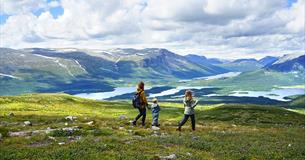 Familie auf Wanderung in offenem Fjellgelände mit Seen und Bergen