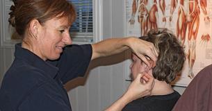 En terapeut setter akupunktur på en pasient.