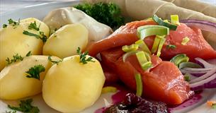 Rakfischteller mit gekochten Kartoffeln, Rakfisch und Beilagen