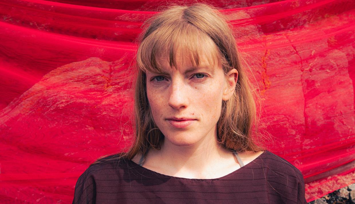 Anna Ueland med rød bakgrunn