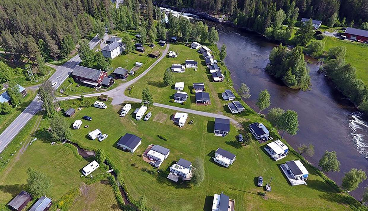 Dronebilde av campingplassen. Idyllisk beliggenhet langs elva.