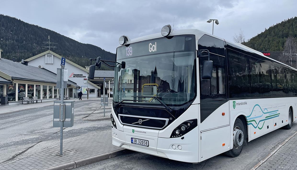 En hvit buss med Innlandstrafikk sin logo på Fagernes Skysstasjon