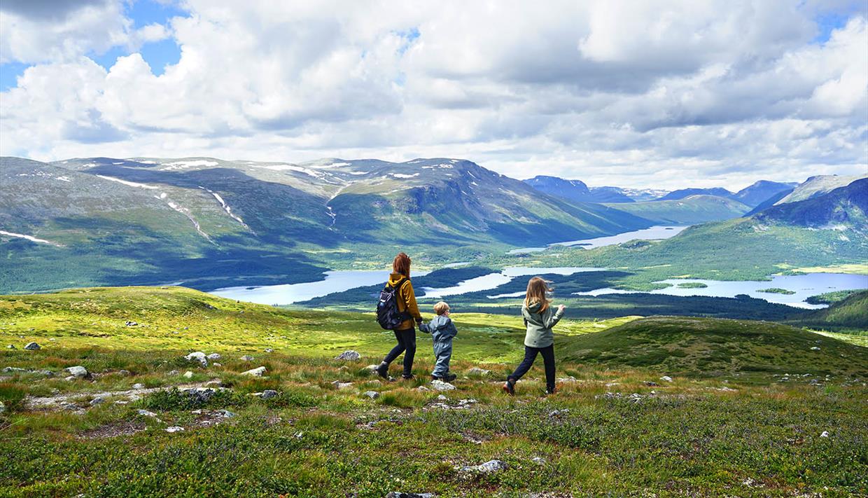 Familie auf Wanderung in offenem Fjellgelände mit Seen und Bergen
