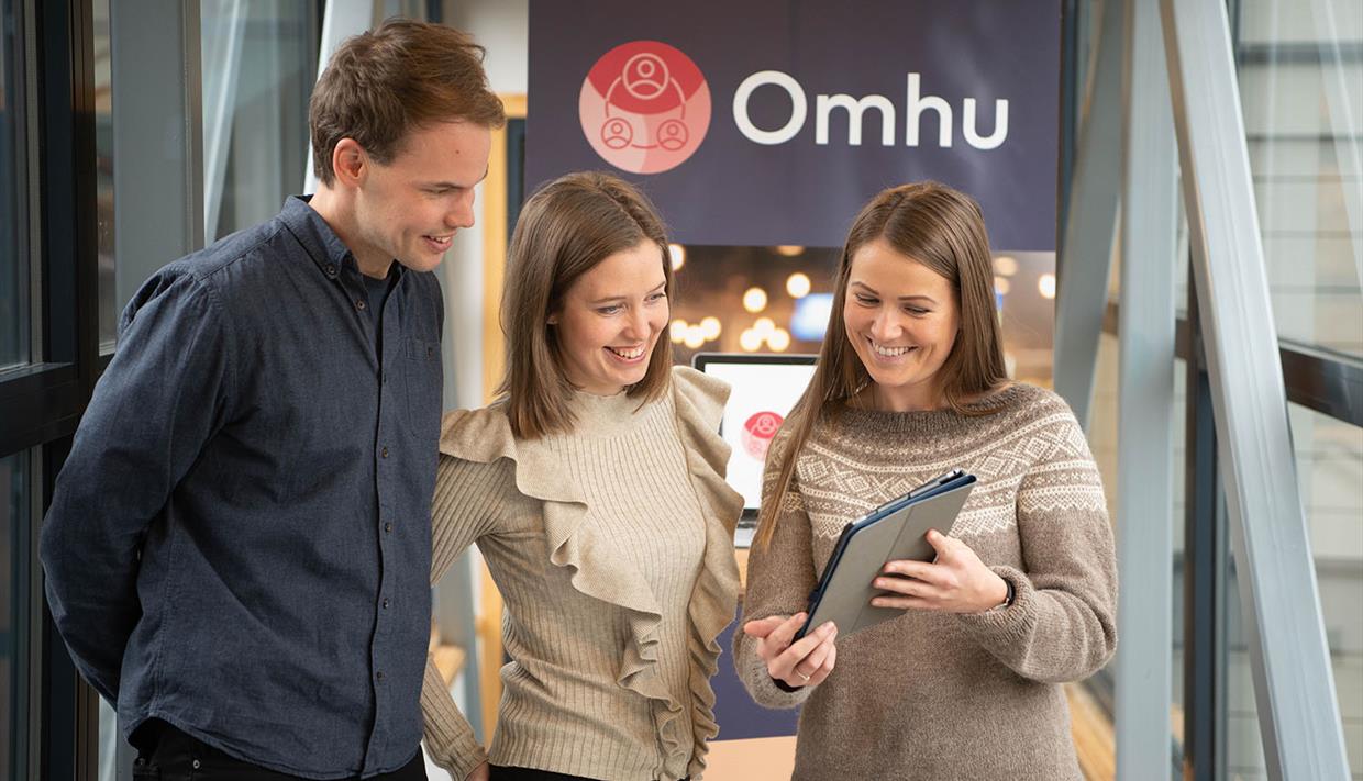 Omhu-ansatte som ser på en iPad
