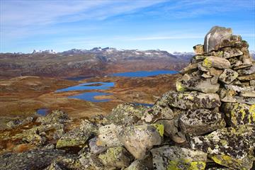 På Tyinstølsnøse med utsikt over vann og fjell mot Hurrunganes spisse tinder i det fjerne.