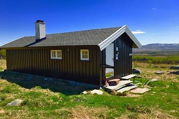 Haldorbu ligger koselig til på en setervoll med utsikt over fjellene i Langsua Nasjonalpark.